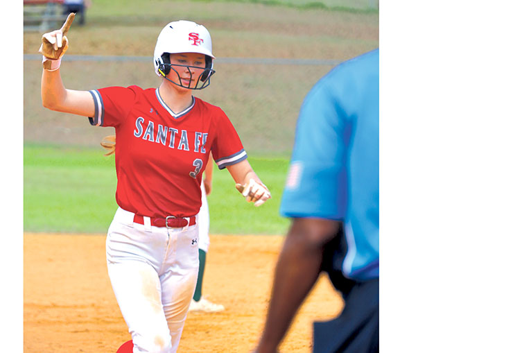 A Santa Fe Raider runner signals as she rounds the base during the 49th Annual Santa Fe Raider Softball Classic at Alachua&rsquo;s Hal Brady Complex. The long-running tournament draws teams from across the region each season. / Photo by RILEY APPLEBEE